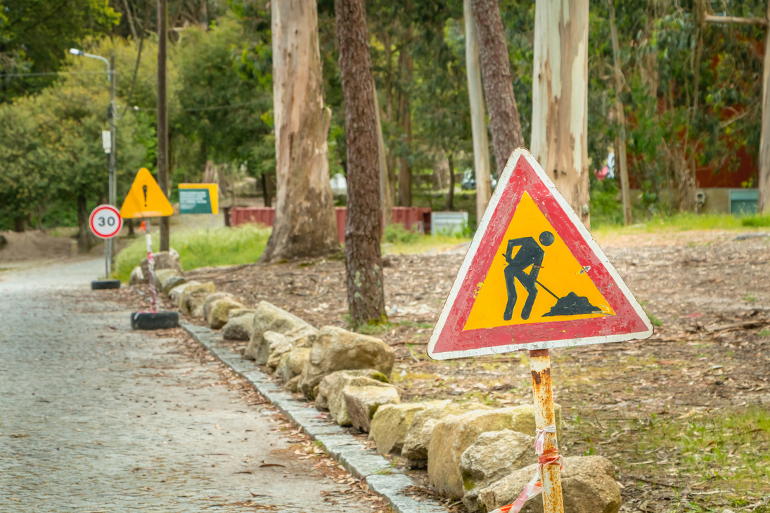 temporary road sign indicating work on a small road in the forest